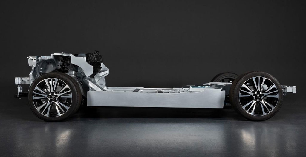 Châssis plateforme CMF-EV Renault exposé en centre technique montrant batterie intégrée au plancher, trains roulants, moteur électrique arrière et empattement généreux, panneaux explicatifs en français
